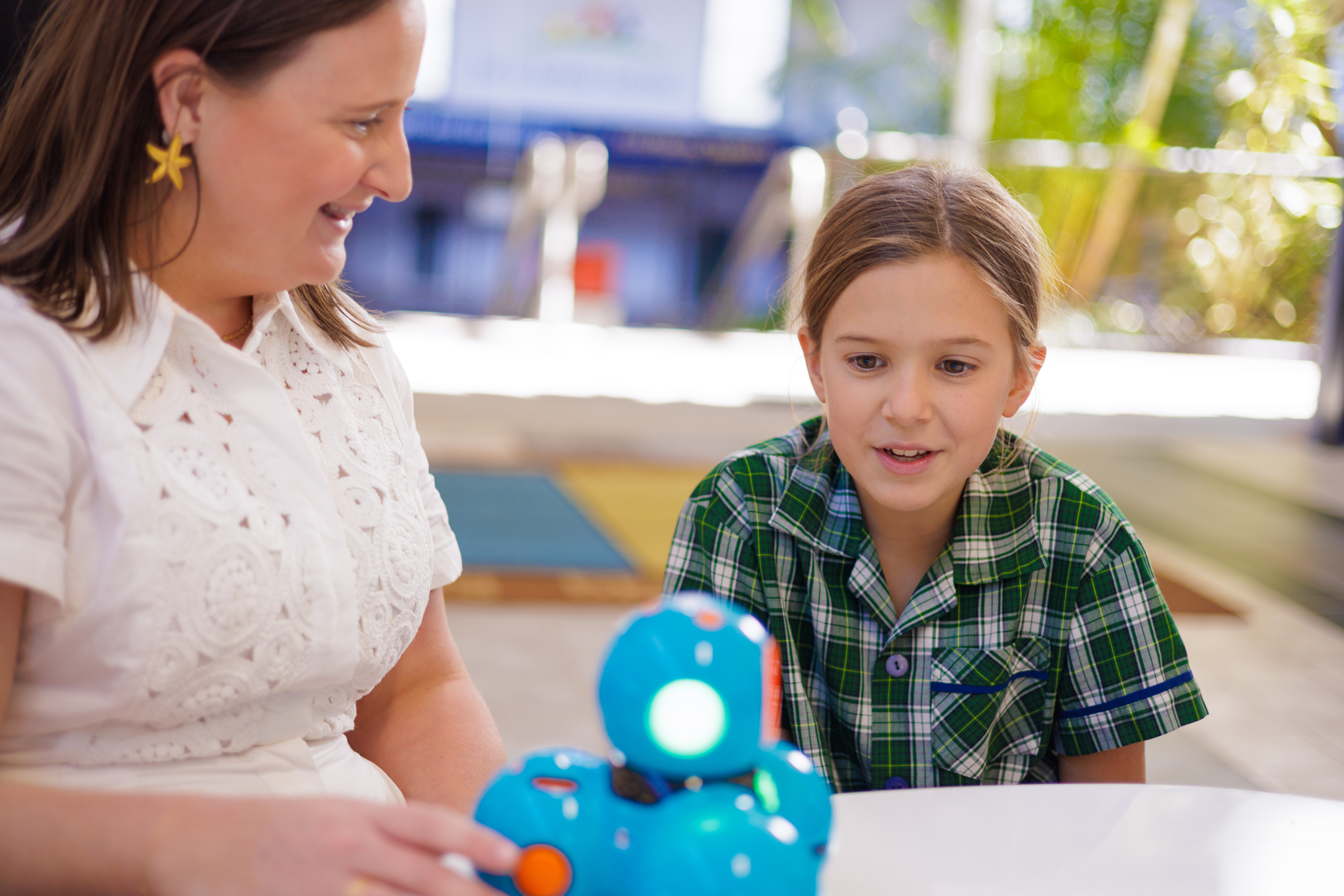 Student exploring a robotics activity with teacher guidance, highlighting hands‑on STEM learning, curiosity and problem solving within a supportive primary school environment