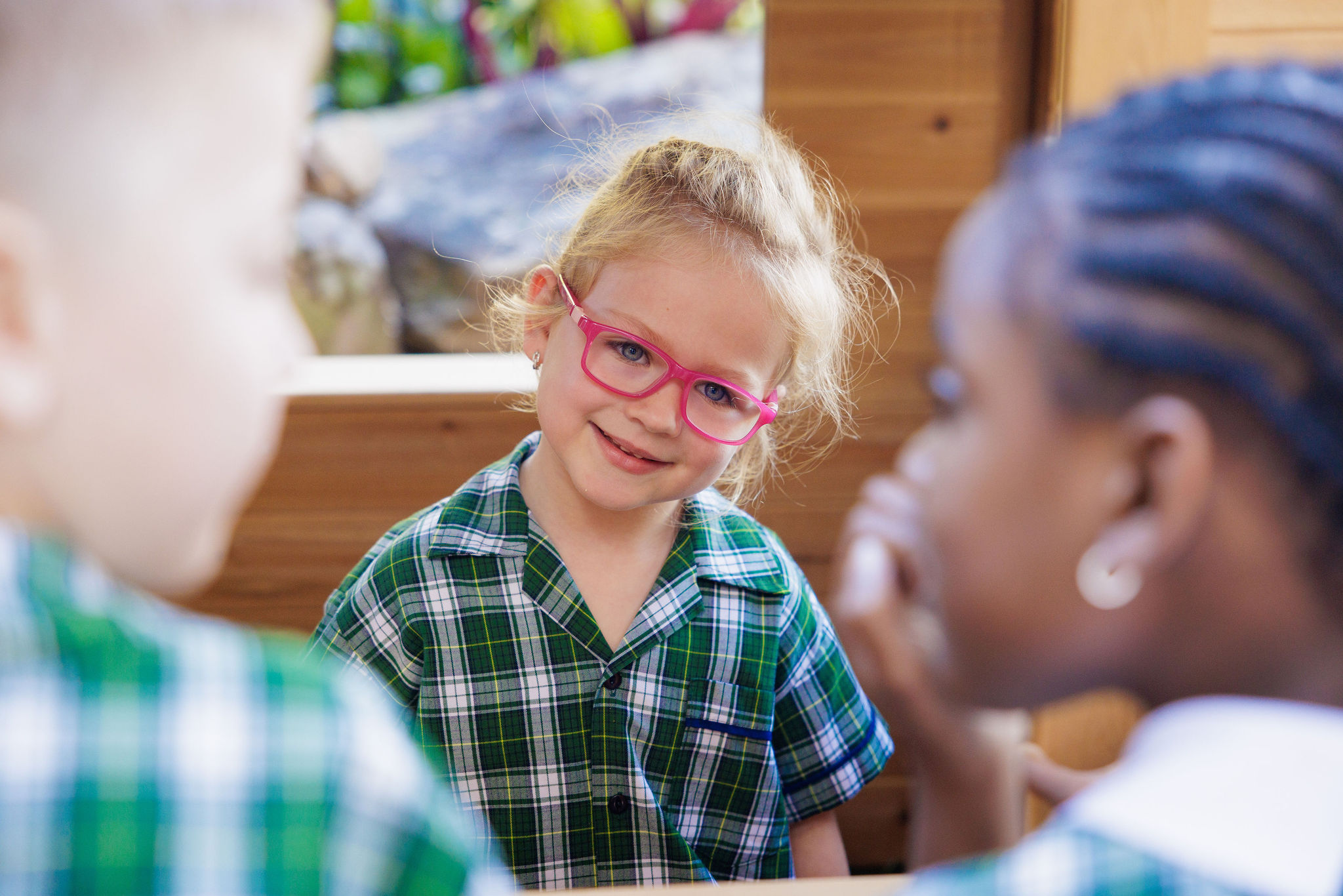 Student engaging in conversation with classmates during a learning activity, highlighting friendship, inclusion and social learning within the primary school environment