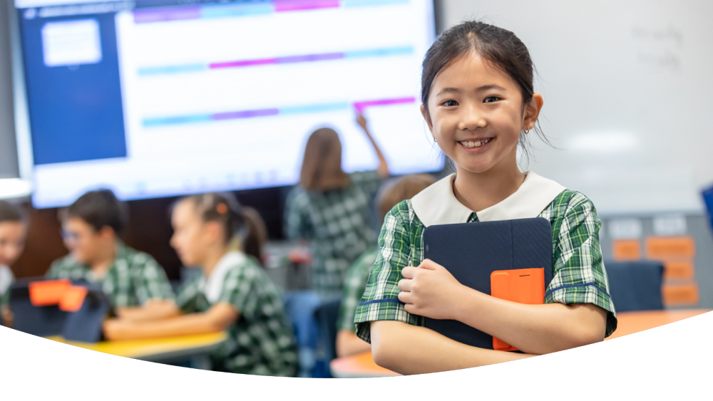 Student in a classroom holding an iPad